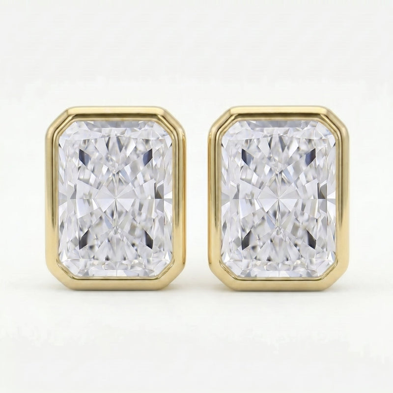 Gold earrings with rectangular diamond-like stones on a white background
