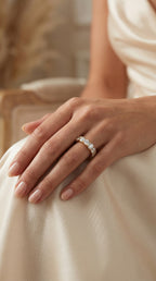 Hand wearing a diamond ring on a soft, blurred background