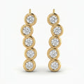 Luxury yellow gold ear crawler earrings with round bezel-set diamonds in angled studio product photo