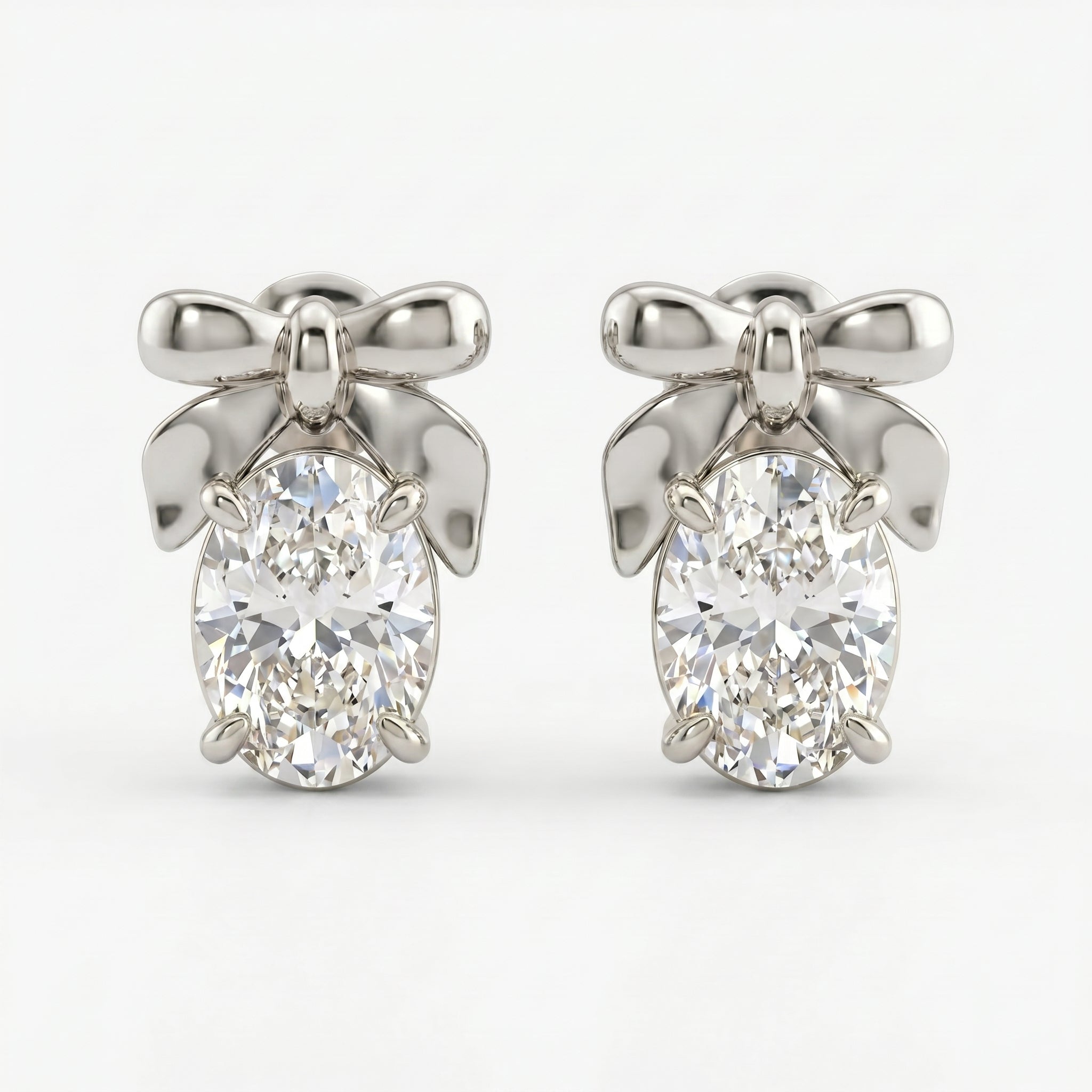 Luxury bow stud earrings with oval gemstones in angled studio view showing polished metal and sparkle detail