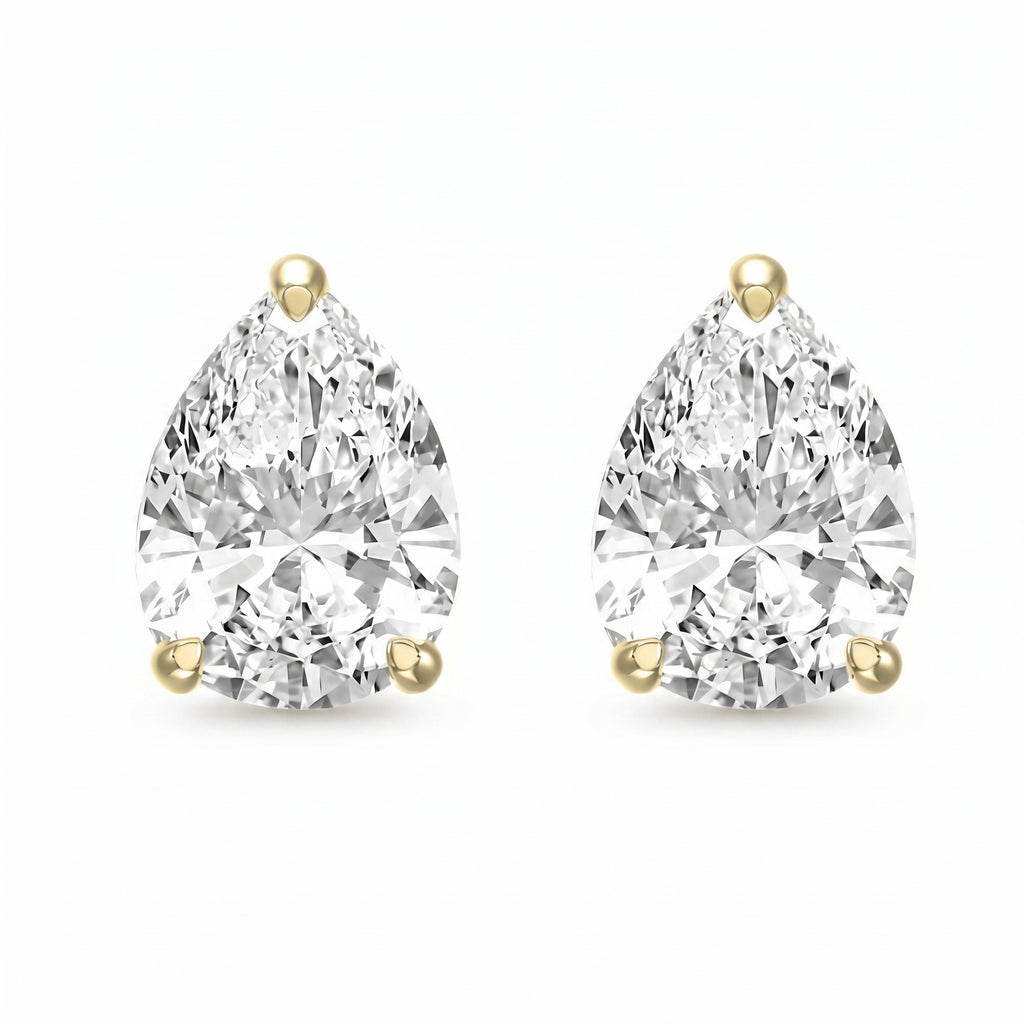 Pair of pear-shaped diamond earrings with gold prongs on a white background