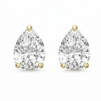 Pair of pear-shaped diamond earrings with gold prongs on a white background
