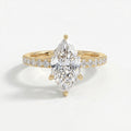 Marquise cut diamond engagement ring in yellow gold with pavé diamond band and six-prong cathedral setting