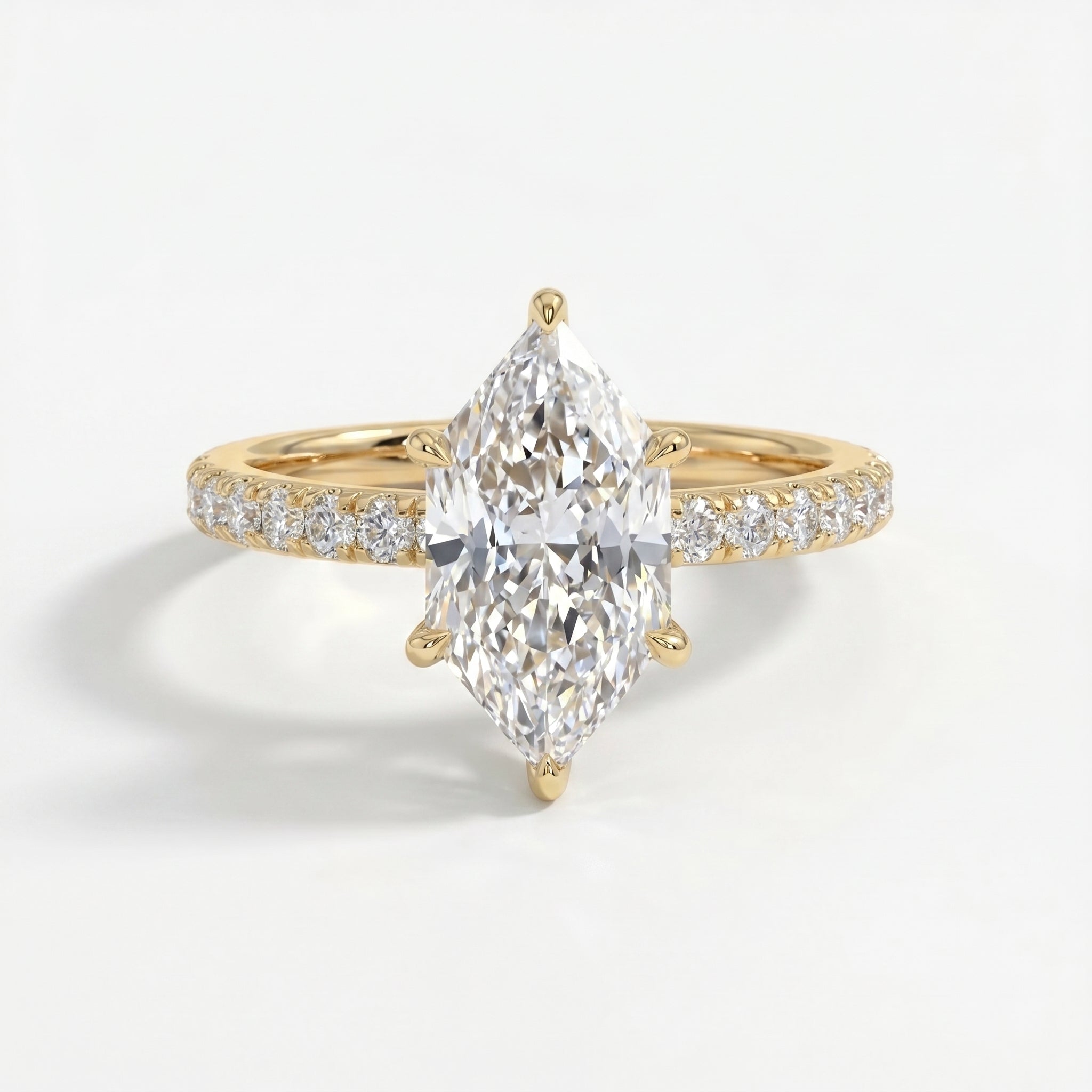 Marquise cut diamond engagement ring in yellow gold with pavé diamond band and six-prong cathedral setting