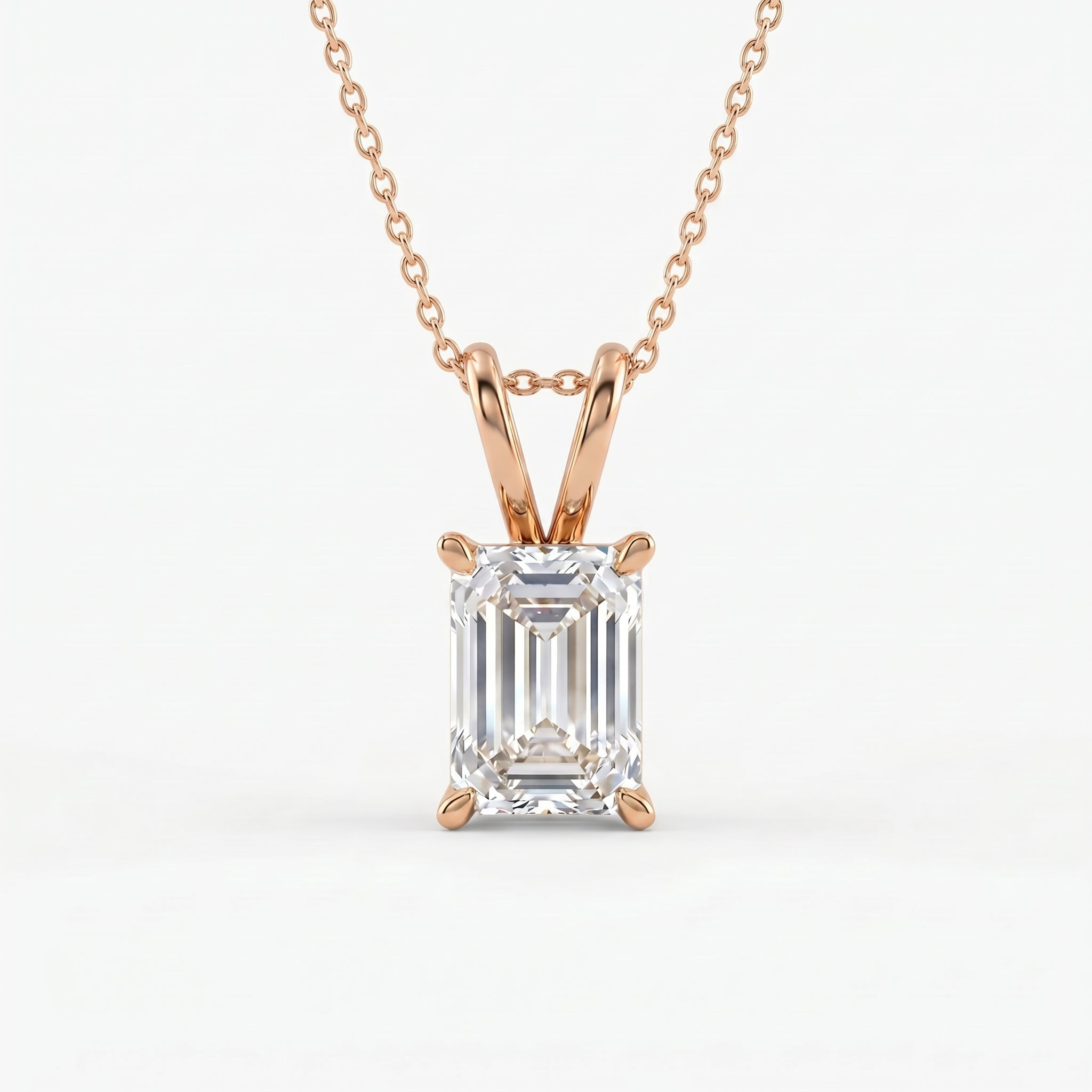 Rose gold necklace with an emerald-cut diamond pendant on a white background