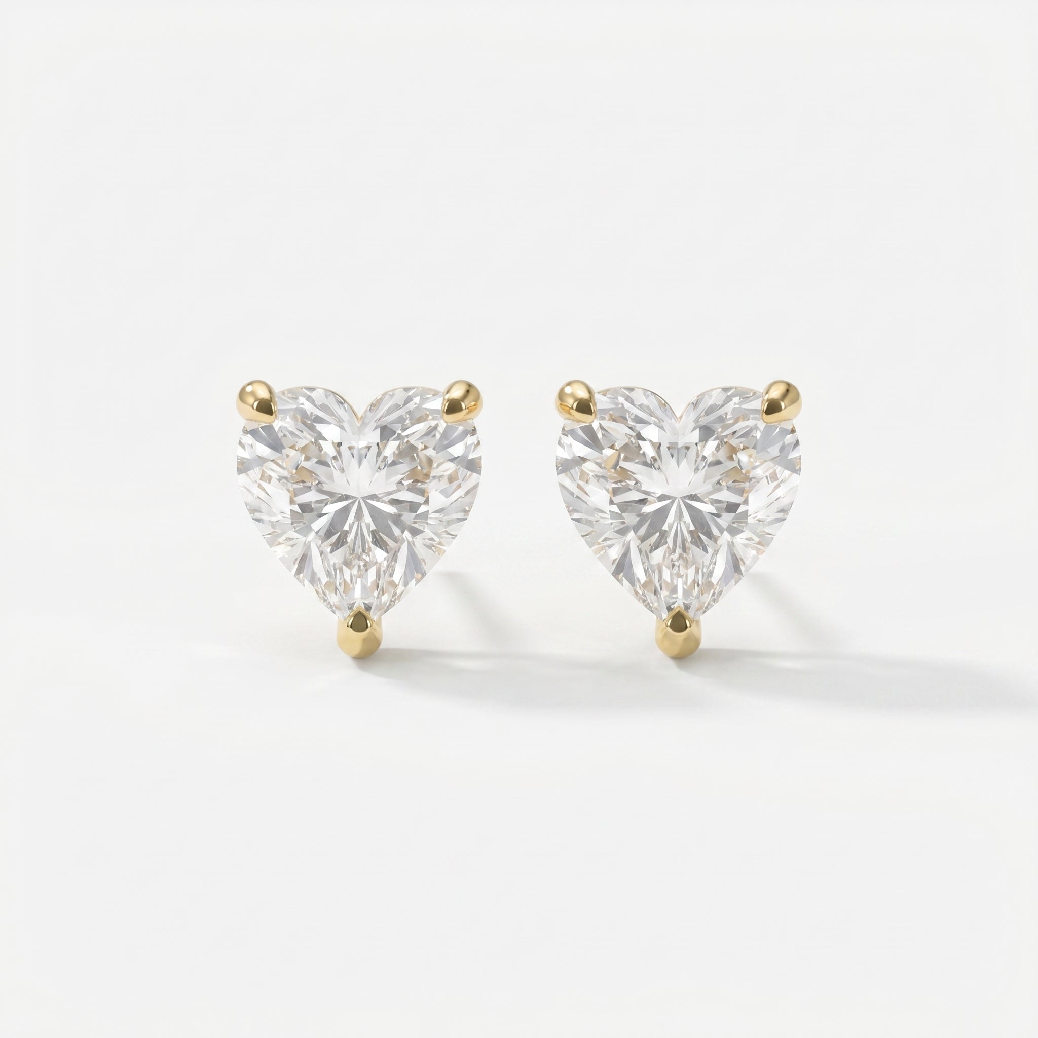Heart-shaped diamond earrings on a white background