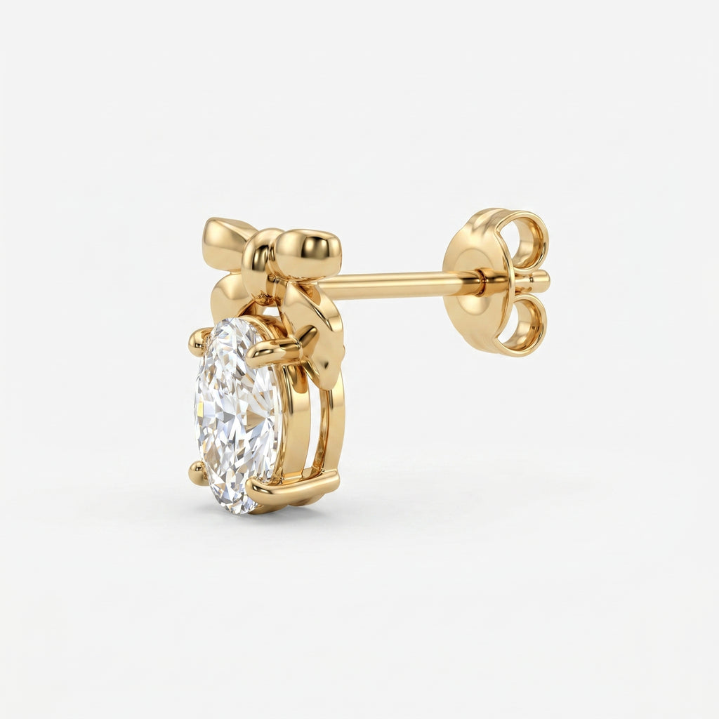 Side profile of polished gold bow stud earrings with oval gemstone and secure prong setting