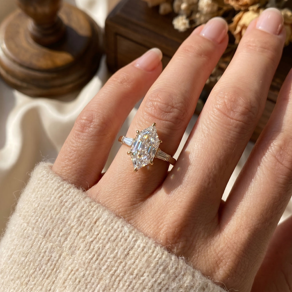 Marquise diamond engagement ring worn on hand featuring tapered baguette side stones and elegant solitaire design