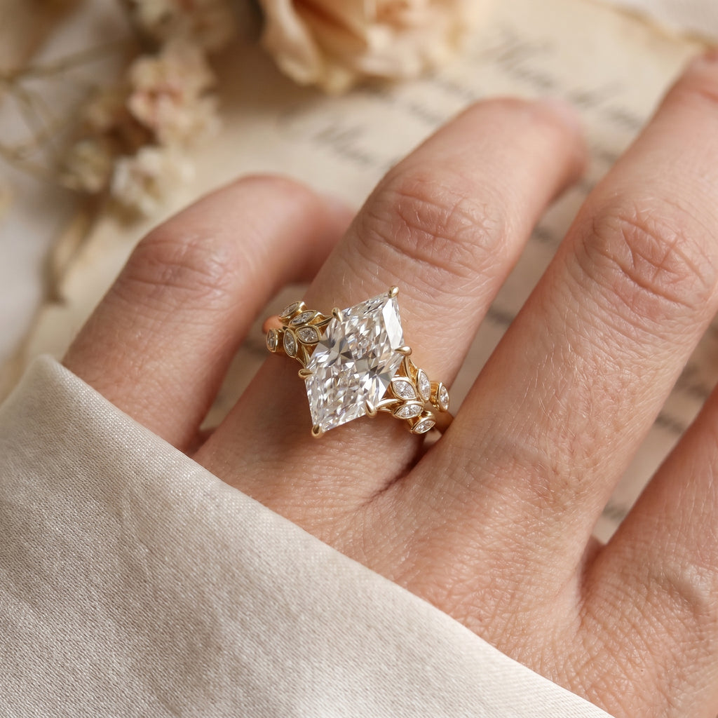 Marquise diamond engagement ring worn on hand featuring nature inspired leaf band and brilliant center stone