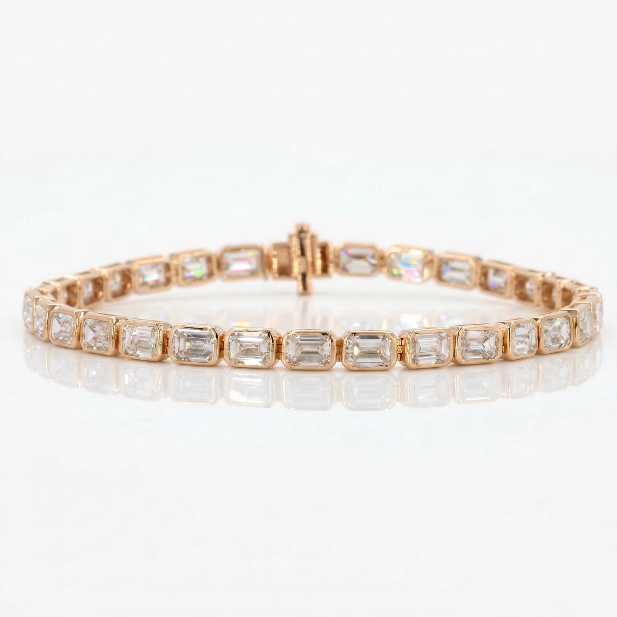 Rose gold bracelet with emerald-cut gemstones on a white background
