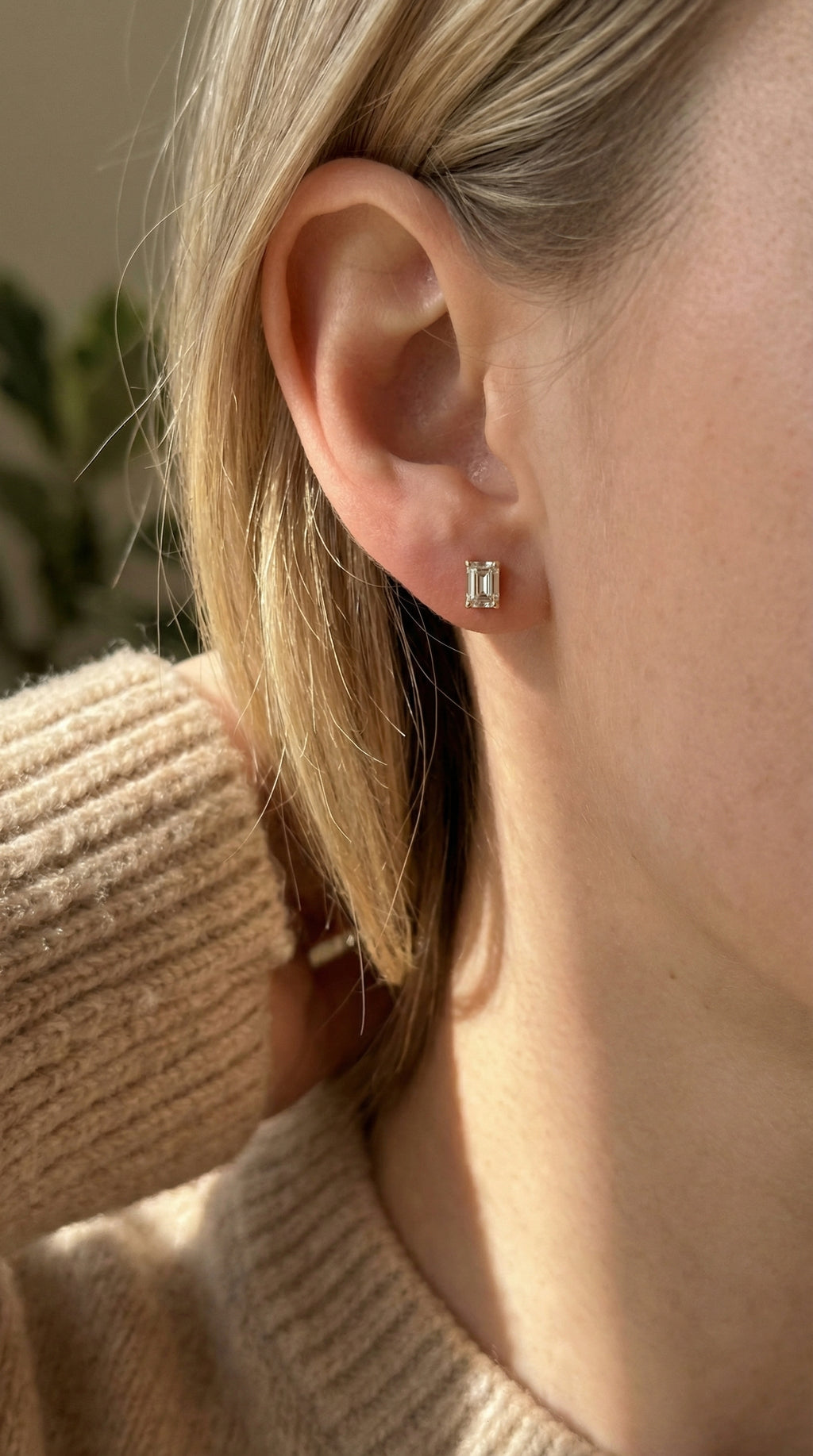 Close-up of an ear wearing a small earring with a blurred background
