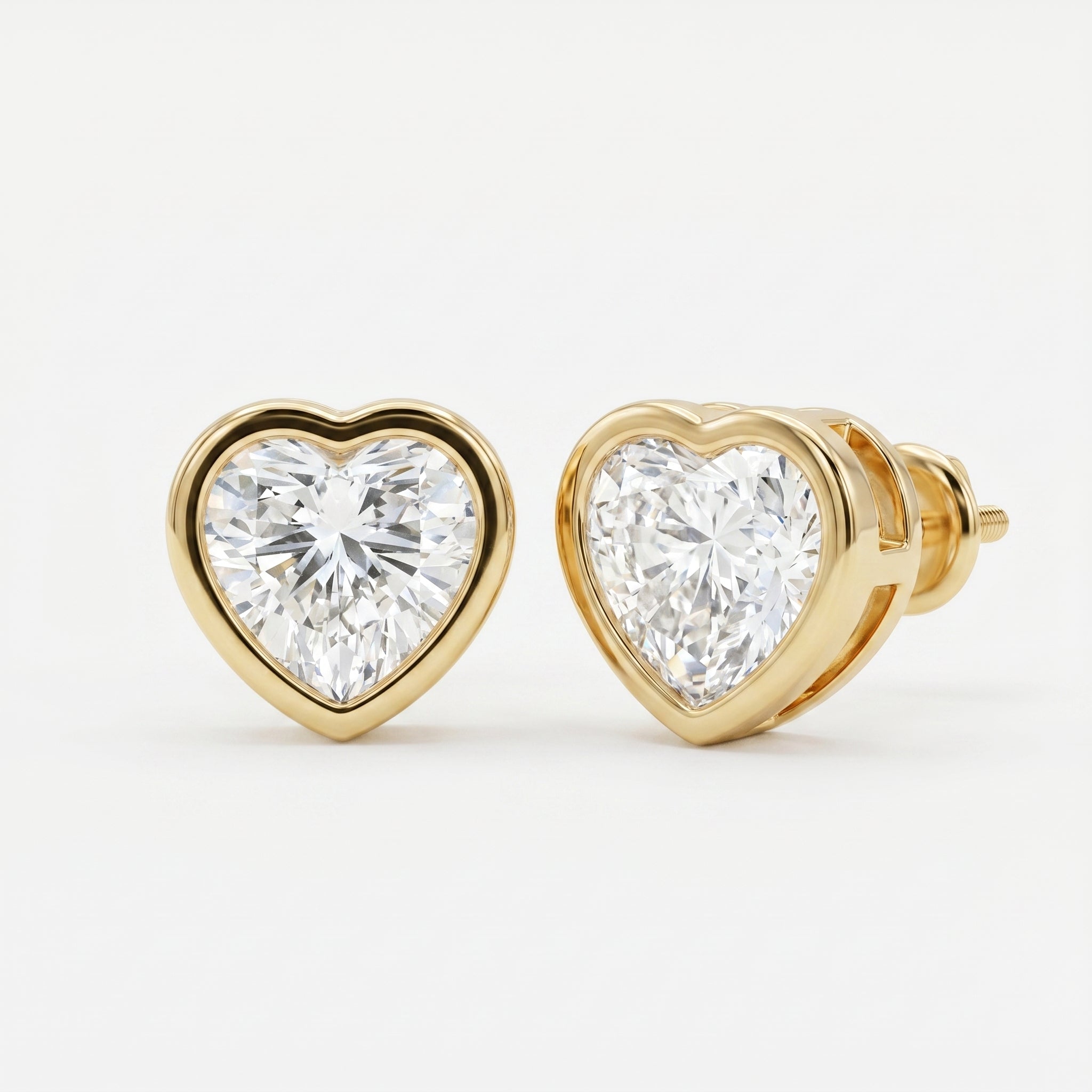 Heart-shaped diamond earrings with gold setting on a white background