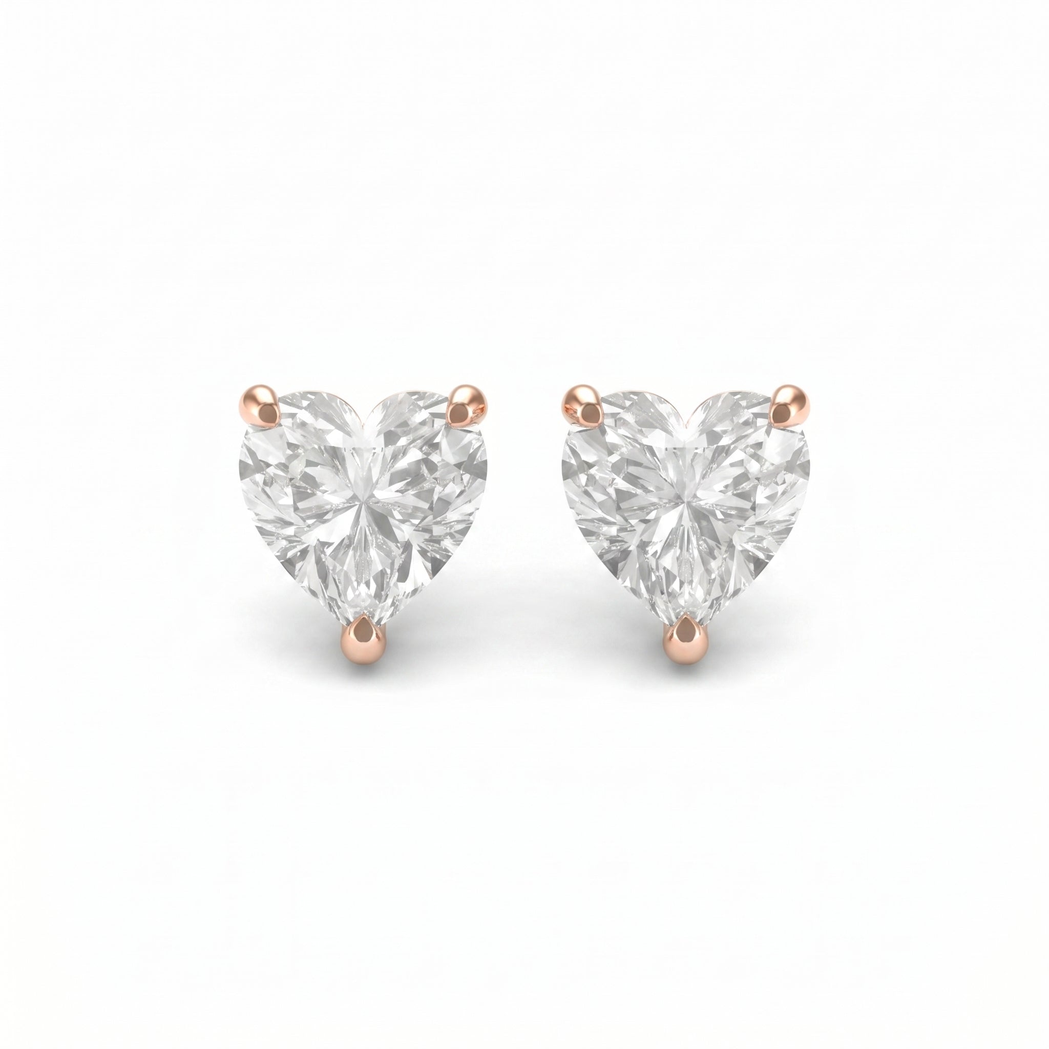 Heart-shaped diamond earrings with rose gold prongs on a white background