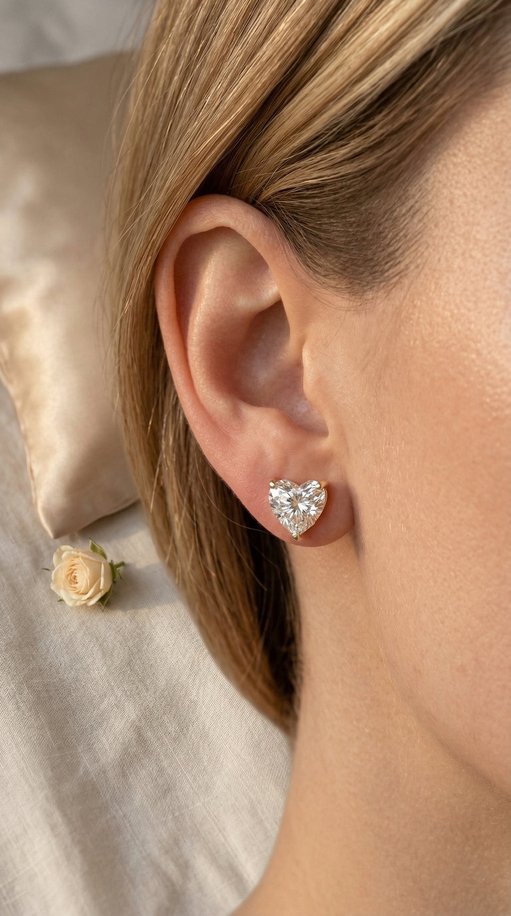 Heart-shaped earrings worn by a person with a neutral background
