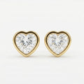 Heart-shaped diamond earrings with gold settings on a white background
