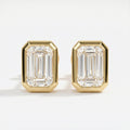 Gold emerald-cut earrings on a white background