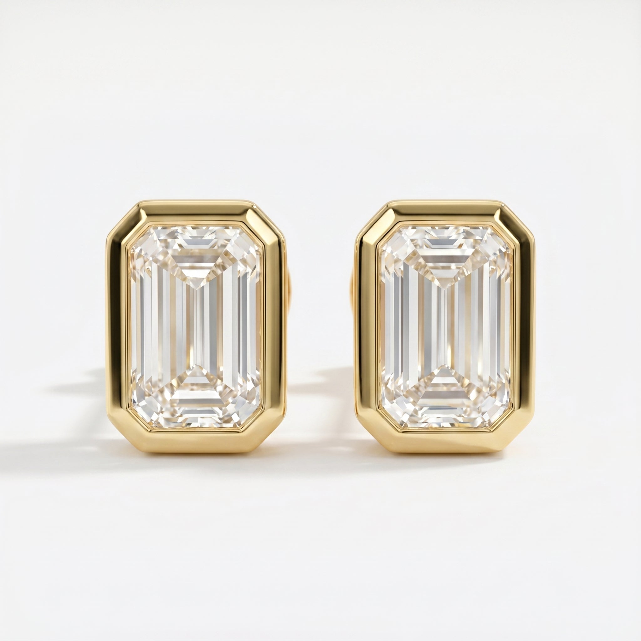 Gold emerald-cut earrings on a white background
