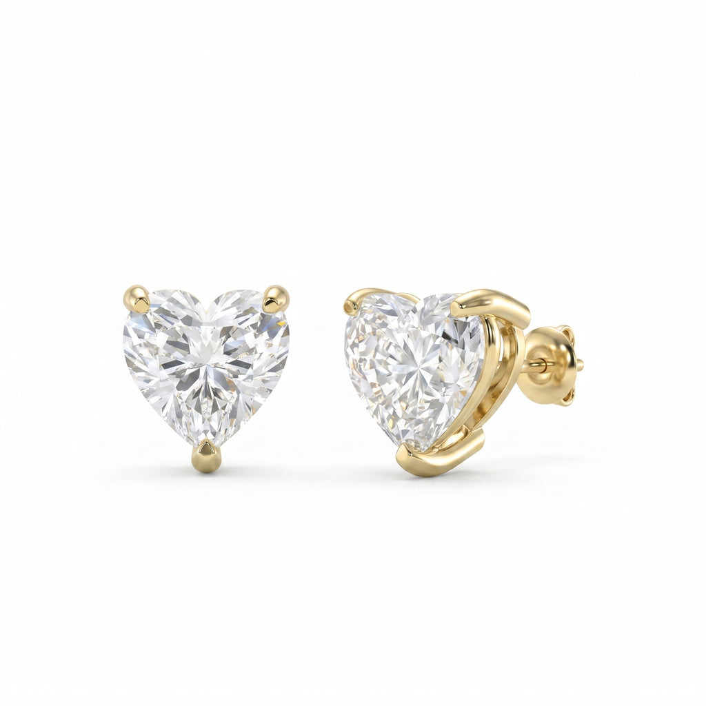 Heart-shaped diamond earrings with gold prongs on a white background
