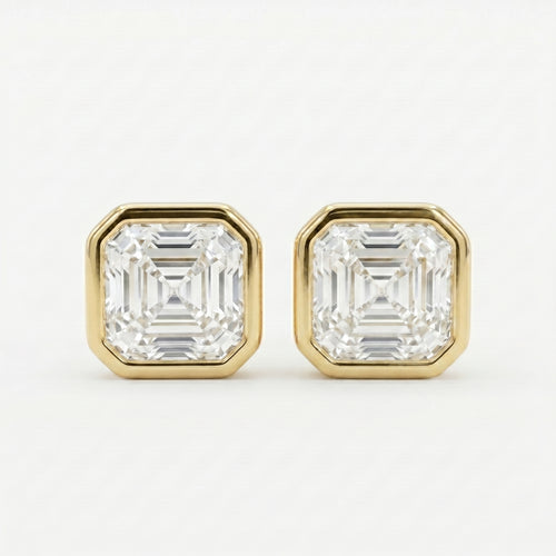 Gold earrings with Asscher-cut gemstones on a white background