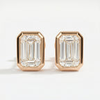 Pair of diamond earrings with rose gold setting on a white background