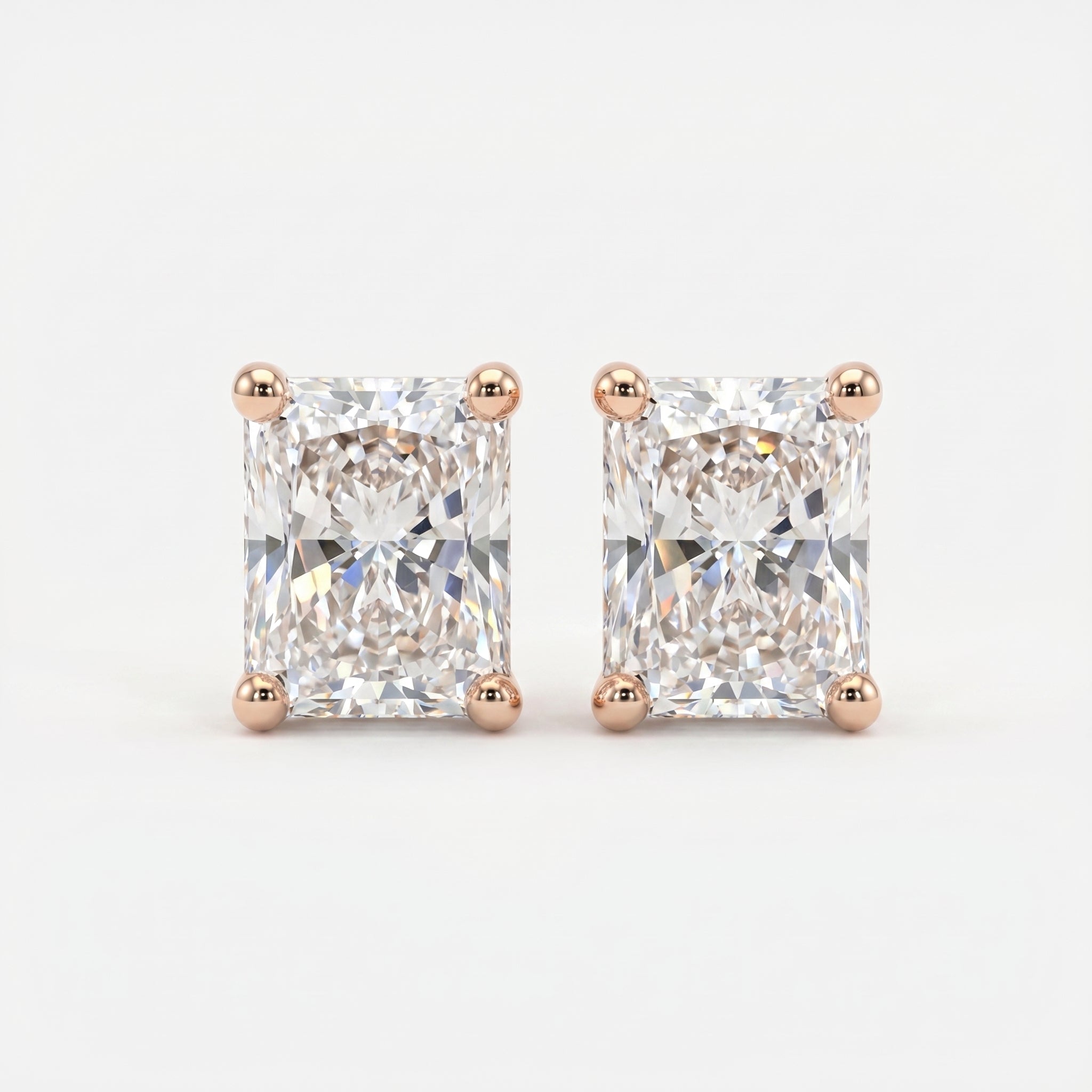 Pair of diamond stud earrings with rose gold prongs on a light gray background