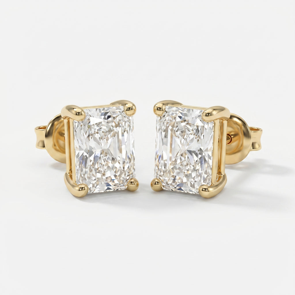 Gold earrings with rectangular cut diamonds on a white background