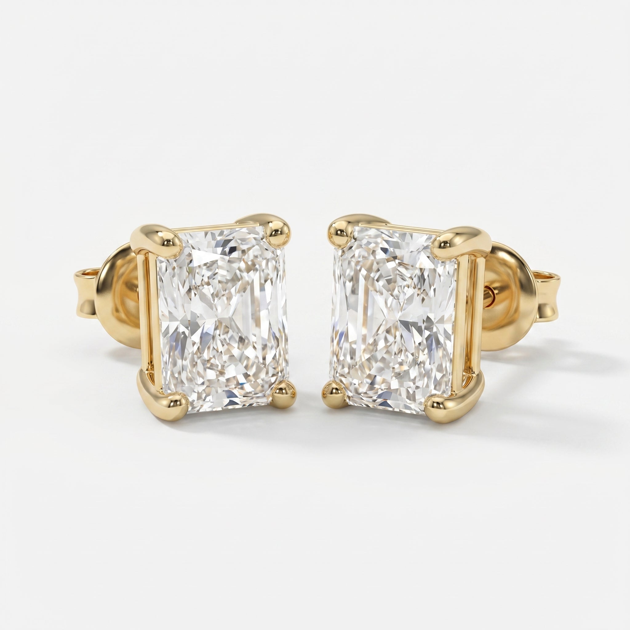 Gold earrings with rectangular cut diamonds on a white background