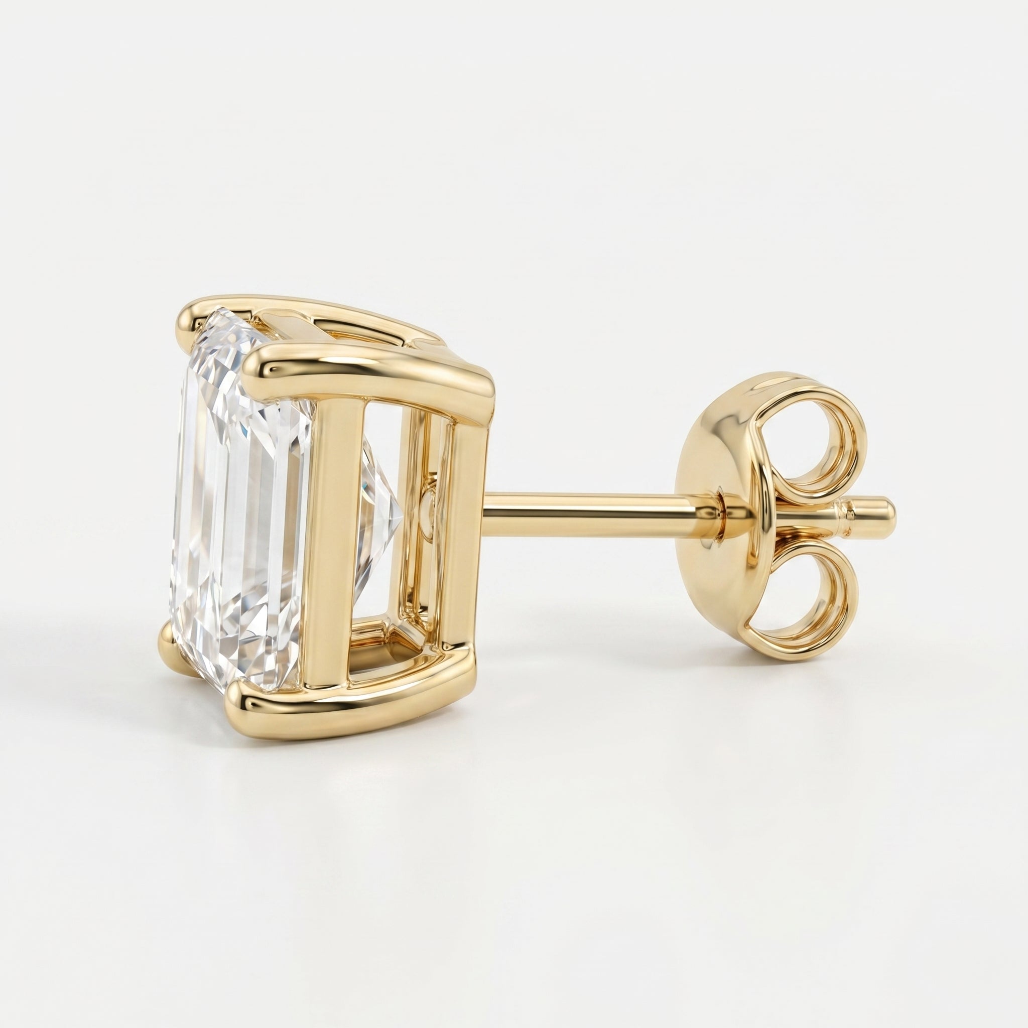 Gold earring with a clear gemstone on a white background