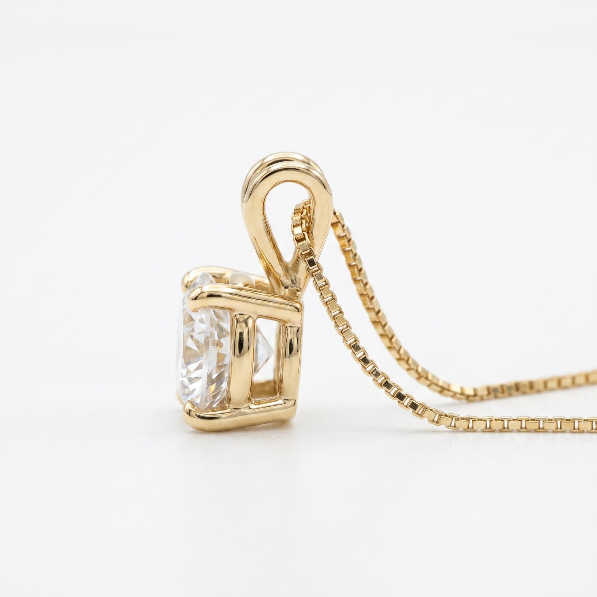 Gold pendant with a large diamond on a white background