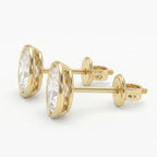 Gold earrings with clear gemstones on a white background