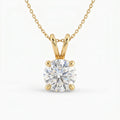 Gold necklace with a round diamond pendant on a white background