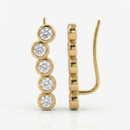 Minimalist yellow gold diamond ear climber earrings with bezel-set round diamonds on white background