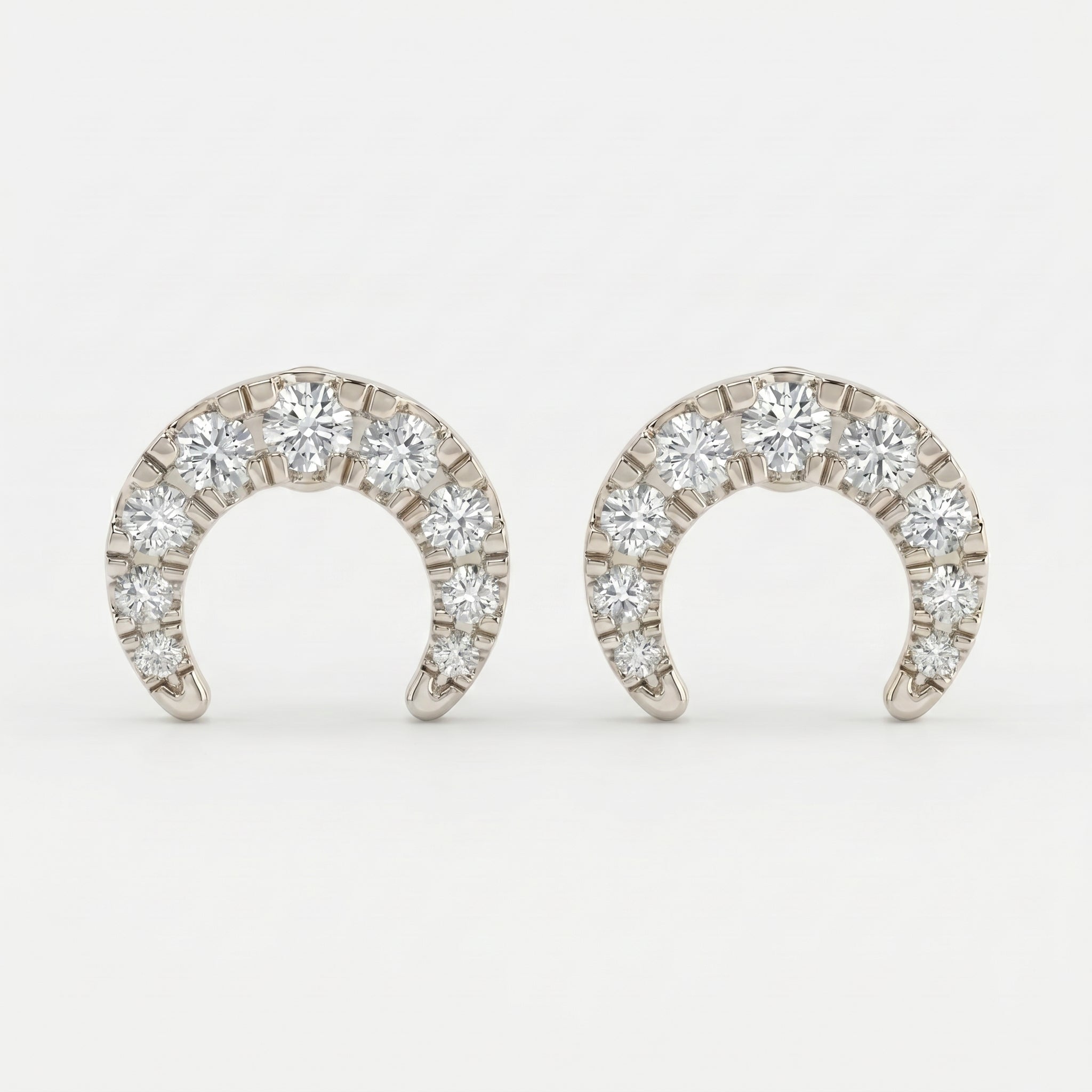 White gold pavé horseshoe stud earrings shown at 45-degree angle with brilliant diamond sparkle