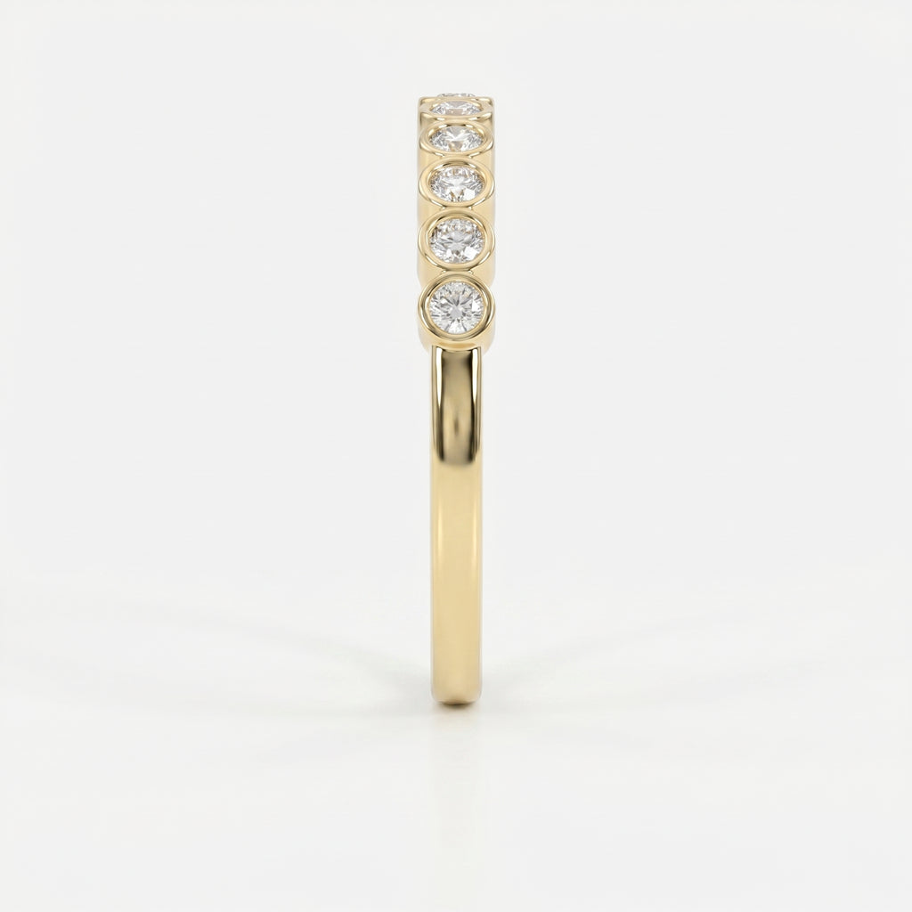 Side profile of yellow gold diamond eternity band showing low-profile bezel setting and comfort fit design