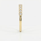 Side profile of yellow gold diamond eternity band showing low-profile bezel setting and comfort fit design