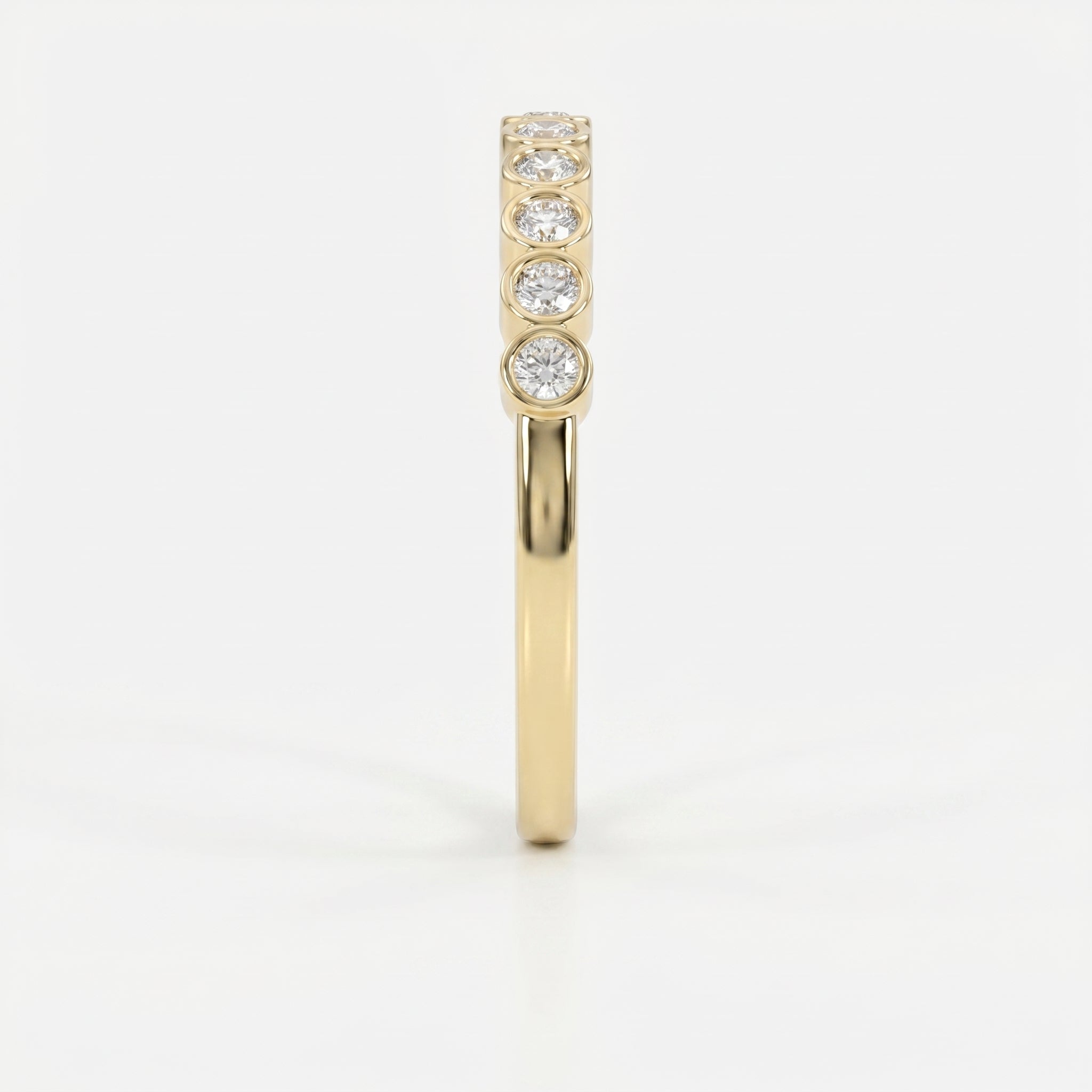 Side profile of yellow gold diamond eternity band showing low-profile bezel setting and comfort fit design