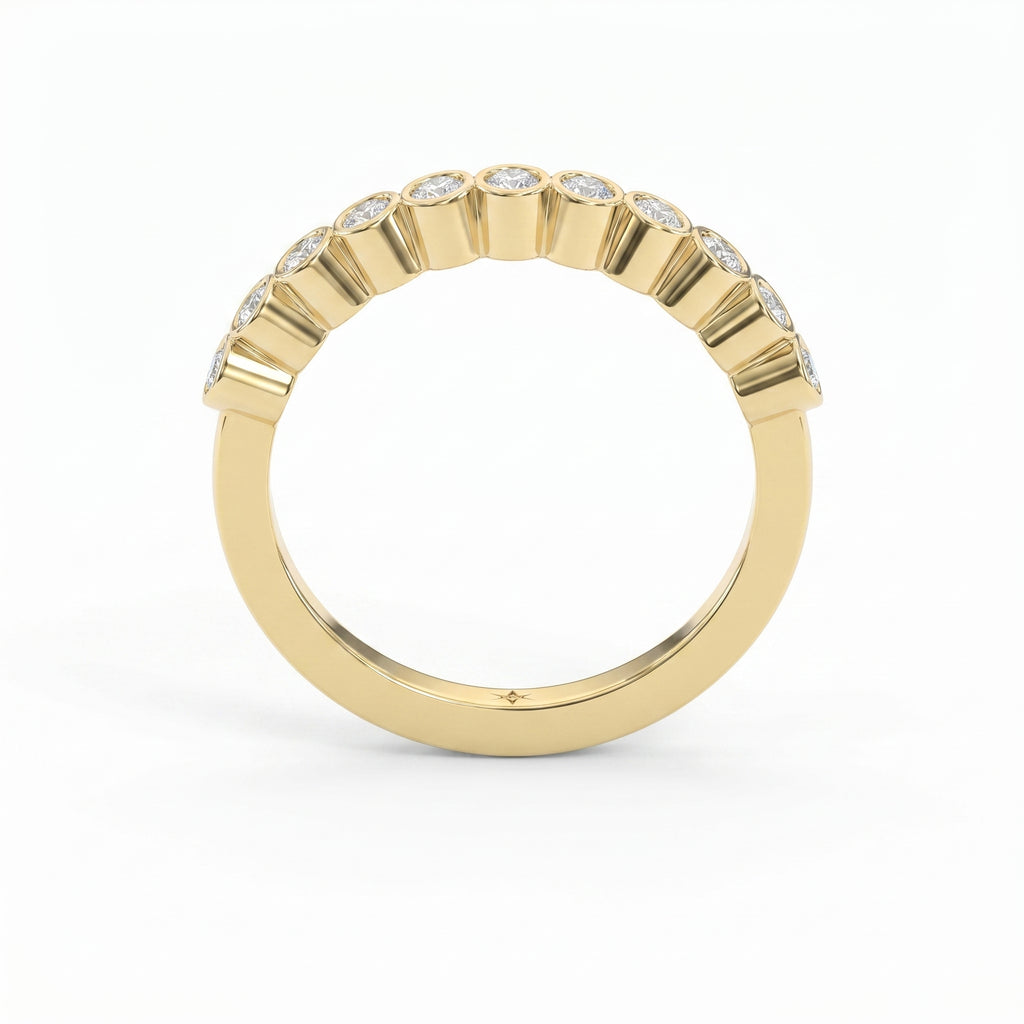 Curved yellow gold diamond wedding band with bezel-set round diamonds, minimalist luxury stacking ring design