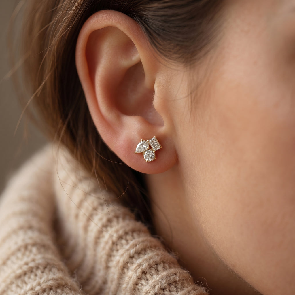 Macro close up of diamond cluster earrings showing emerald pear and round cut stone brilliance