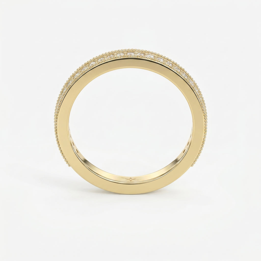 Diamond eternity band in yellow gold featuring round brilliant diamonds and milgrain detailing on a white background.