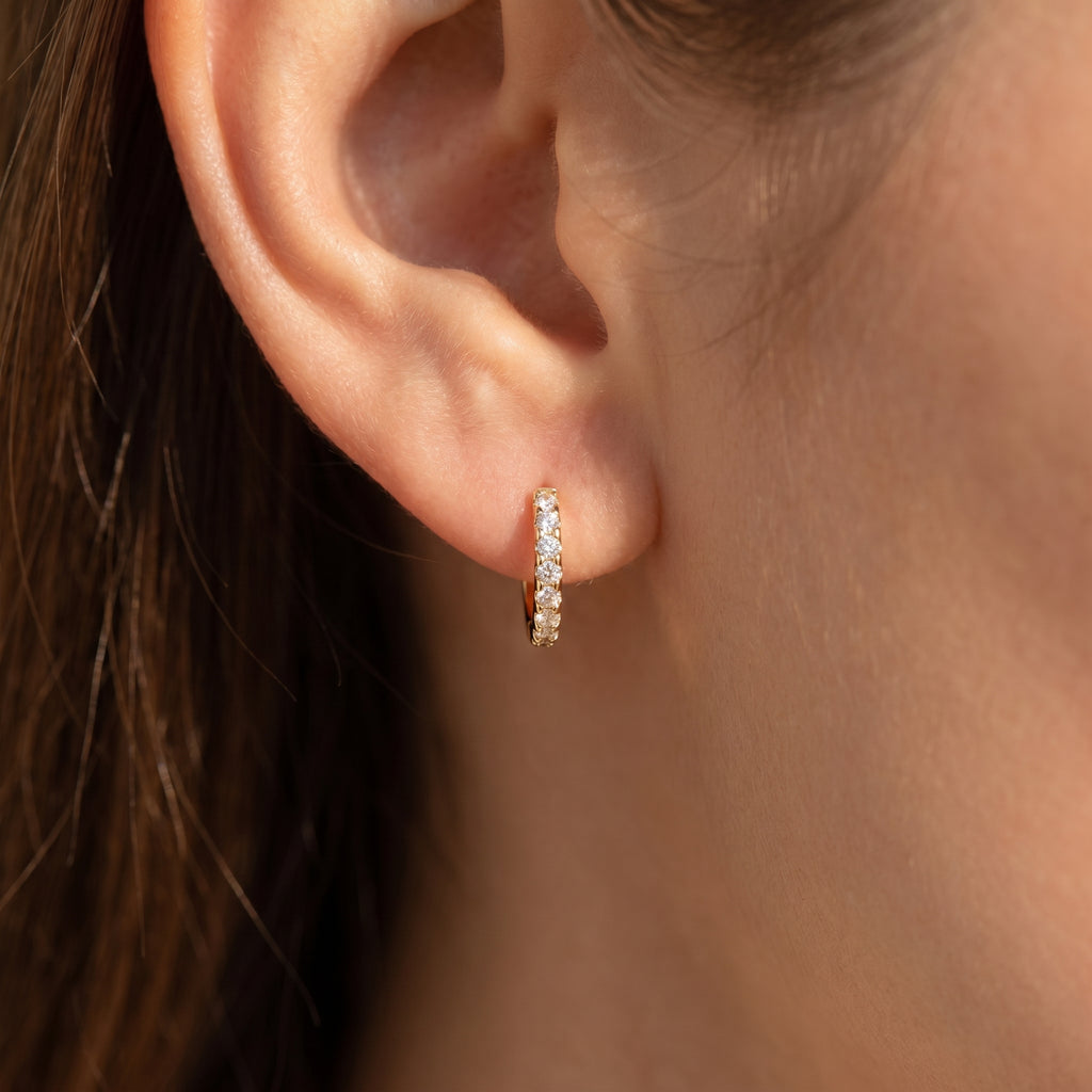 Luxury diamond huggie hoop earrings styled in elegant flat lay composition with modern minimal aesthetic
