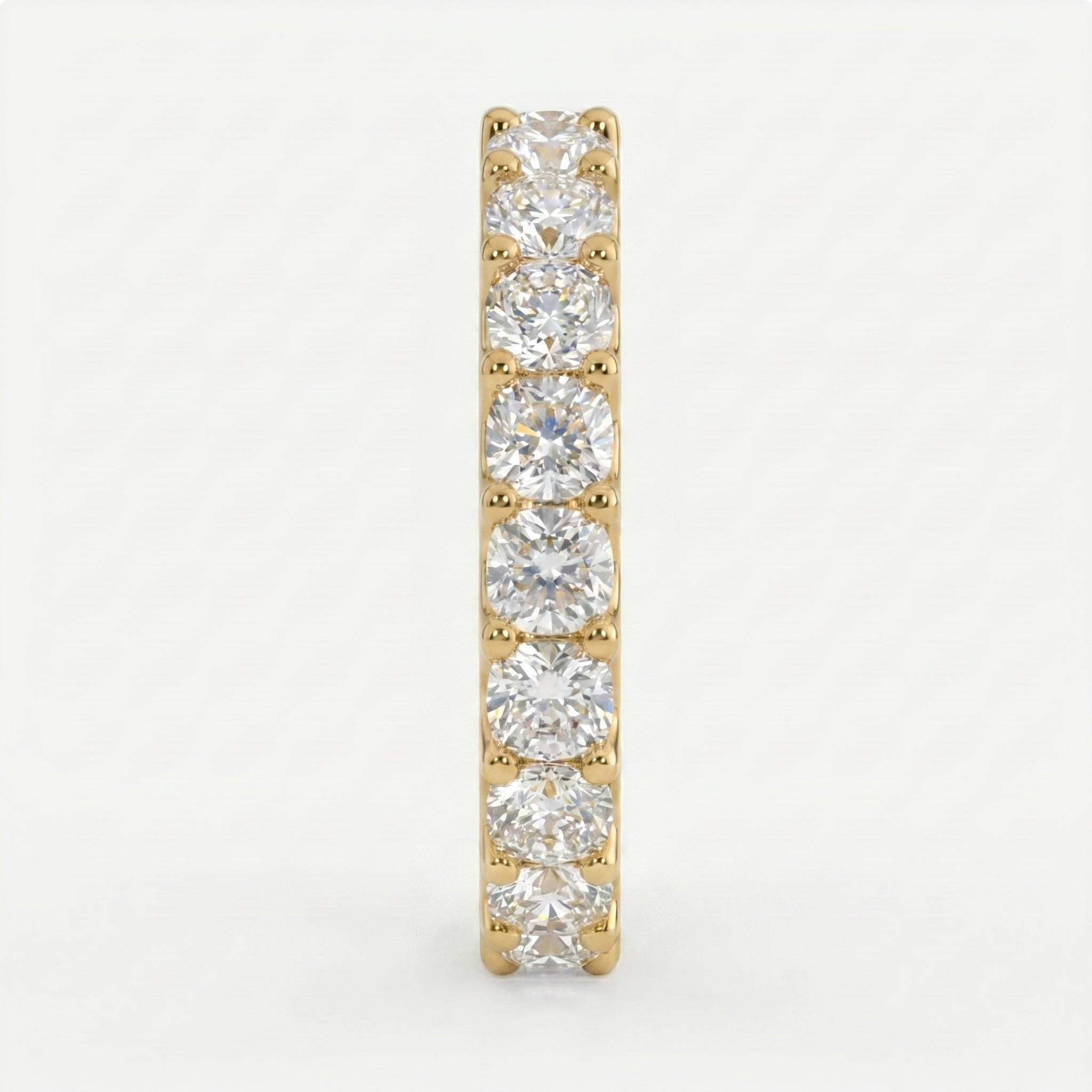 Gold earring with clear gemstones on a light gray background