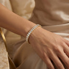 Emerald cut diamond tennis bracelet in gold setting featuring continuous sparkling stones and secure clasp design