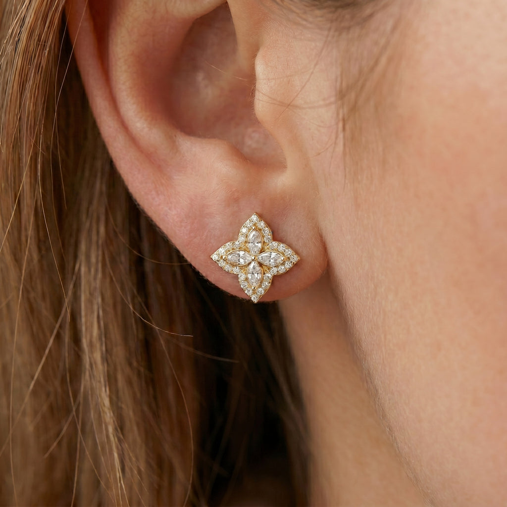 Yellow gold floral stud earrings with marquise diamonds shown at angled perspective with premium sparkle