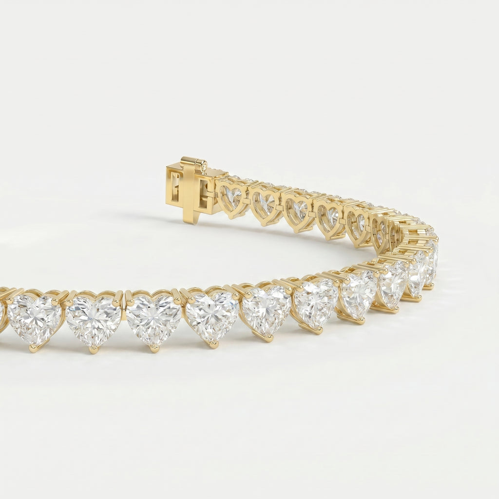 Heart-shaped diamond tennis bracelet in polished yellow gold shown at 45-degree angle highlighting sparkle and detail