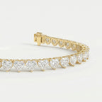 Heart-shaped diamond tennis bracelet in polished yellow gold shown at 45-degree angle highlighting sparkle and detail