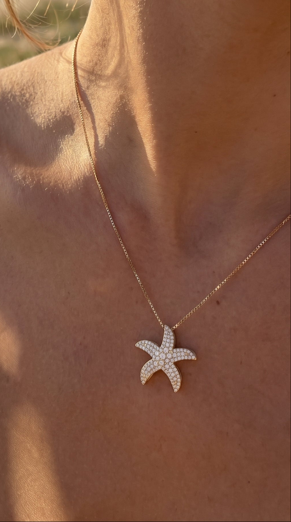 Starfish necklace on a person with a beach background