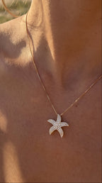 Starfish necklace on a person with a beach background