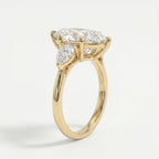 Yellow gold marquise diamond engagement ring with pear side stones shown at a 45 degree luxury studio angle
