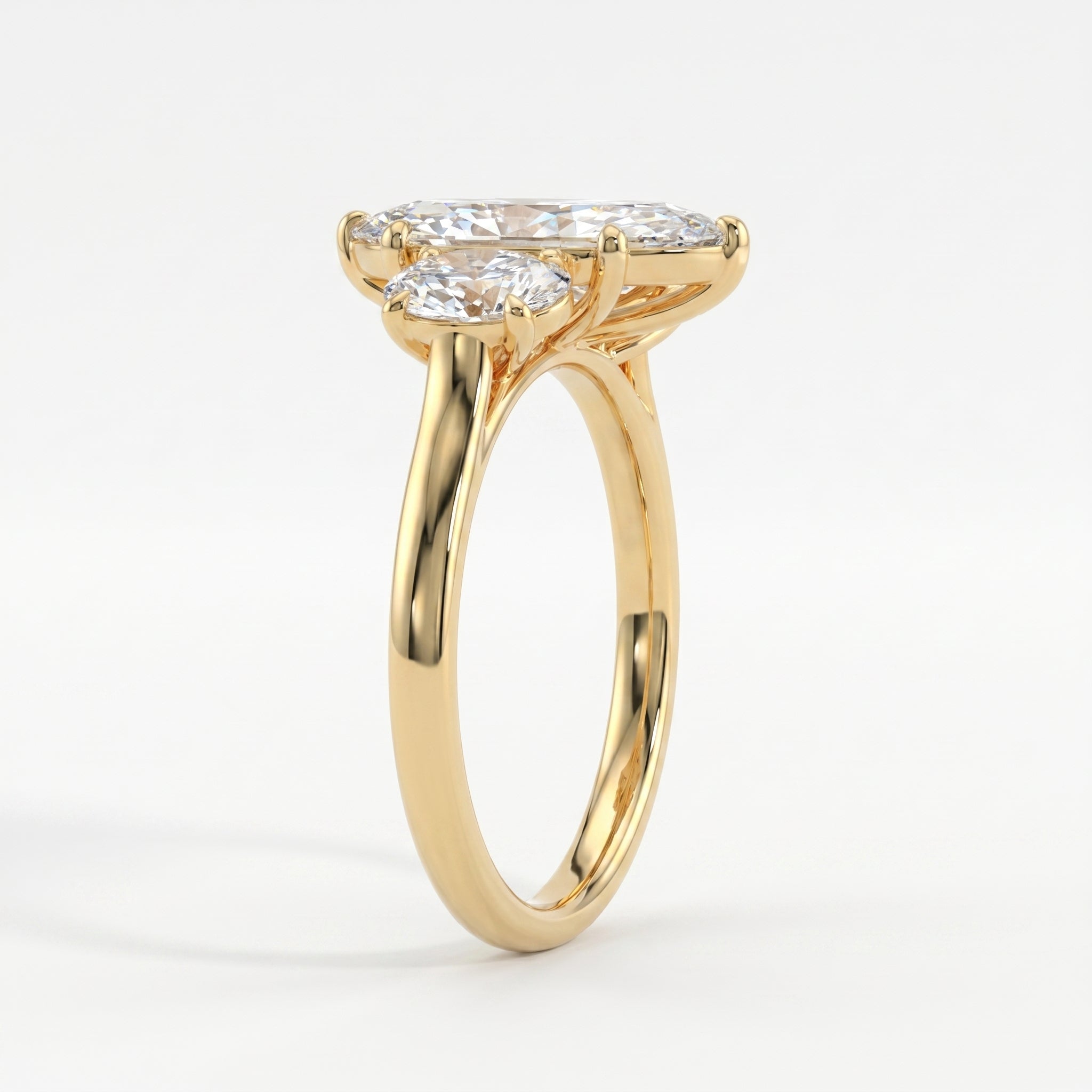 Side profile of marquise diamond engagement ring showing oval side stones and yellow gold setting