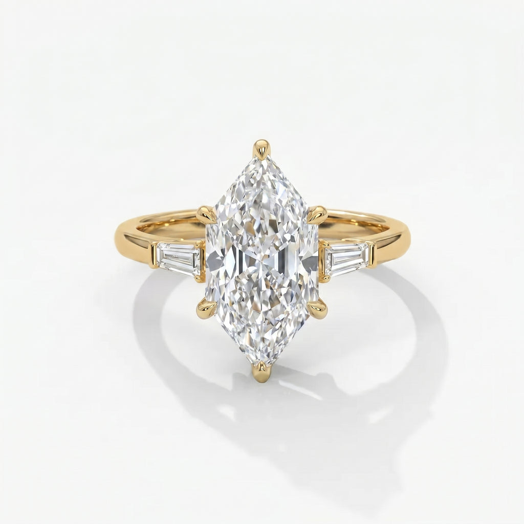 Marquise diamond engagement ring with tapered baguette side stones in polished yellow gold on white background